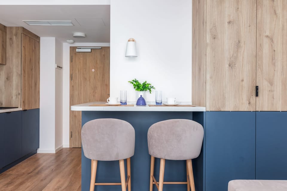 A bar-style kitchen setup with two tall stools and a minimalist countertop.

