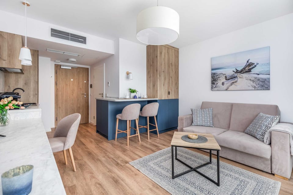 A cozy living room with a wooden coffee table, stylish chairs, and modern artwork on the wall.
