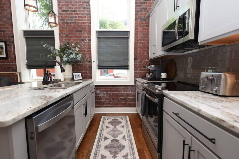 Kitchen: Stylish space with sleek appliances and charming brick walls—perfect for culinary adventures!