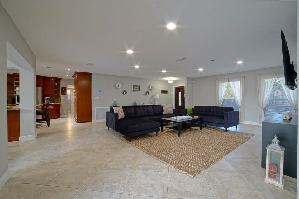 Living-room area with a sectional sofa, a loveseat and smart TV.