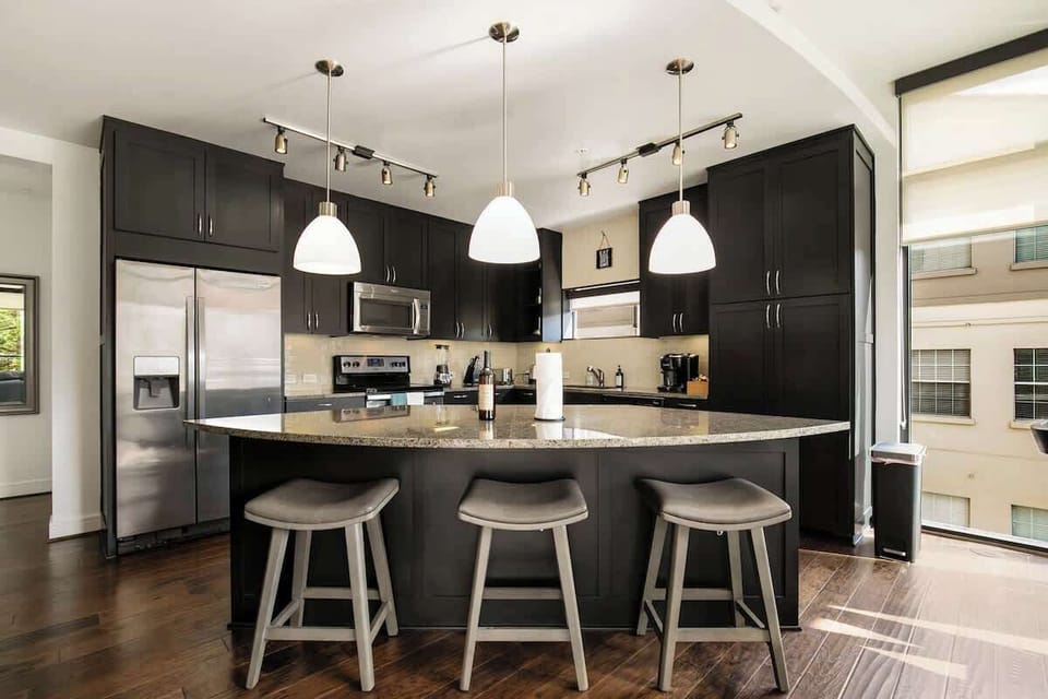 Sleek black cabinets and granite countertops make meal prep a delight in this stylish space!