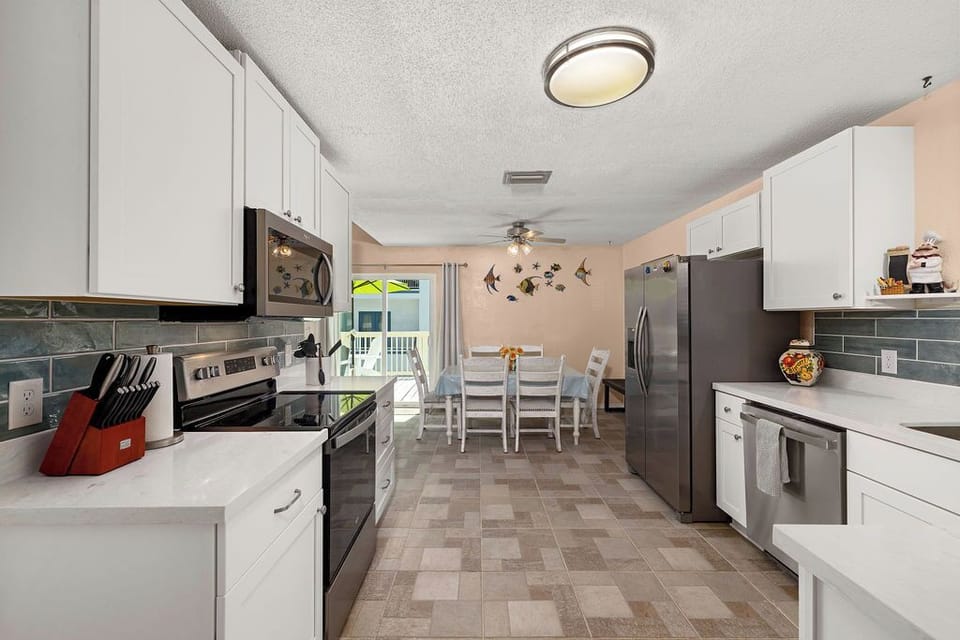 Newly remodeled kitchen with new stainless steel appliances, countertops, backslash and new tile