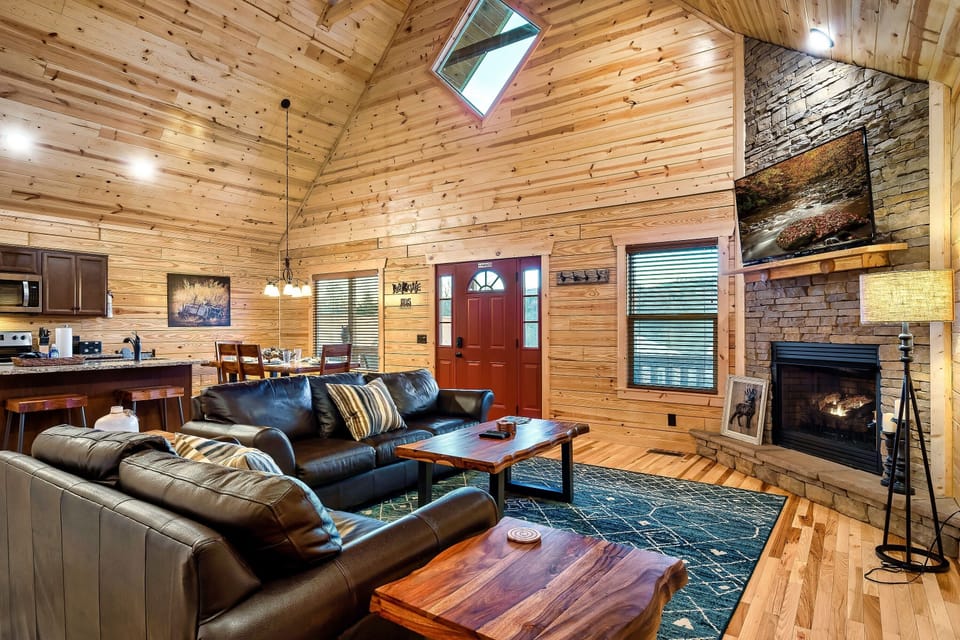 Family room with cozy couches, warming fireplace and smart TV