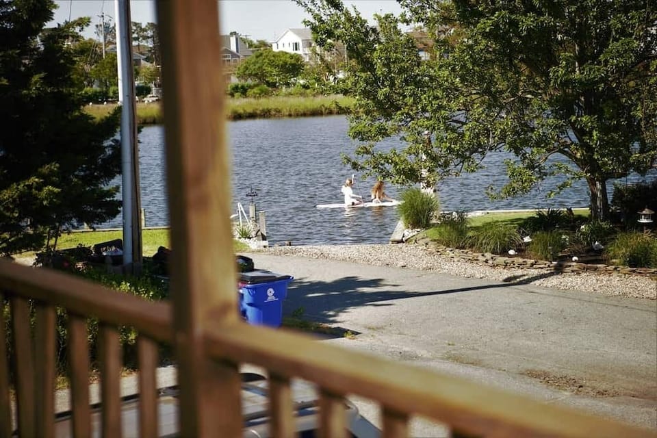 View from upper level porch of people paddle boarding