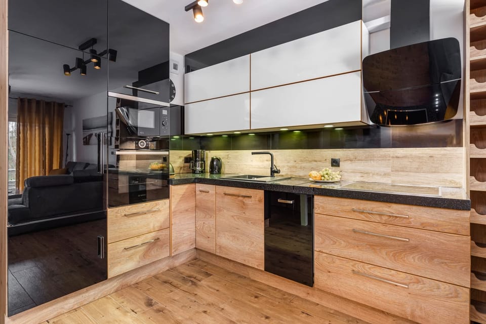 A kitchen close-up showing the stovetop and countertop with a modern, polished finish. Fresh fruit adds a pop of color to the minimalist design.