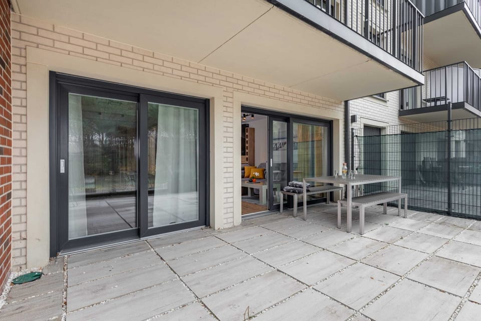 A spacious terrace with a set of outdoor furniture and decorative potted plants. It’s an ideal spot for morning coffee or evening gatherings, with a picturesque view of the landscape.