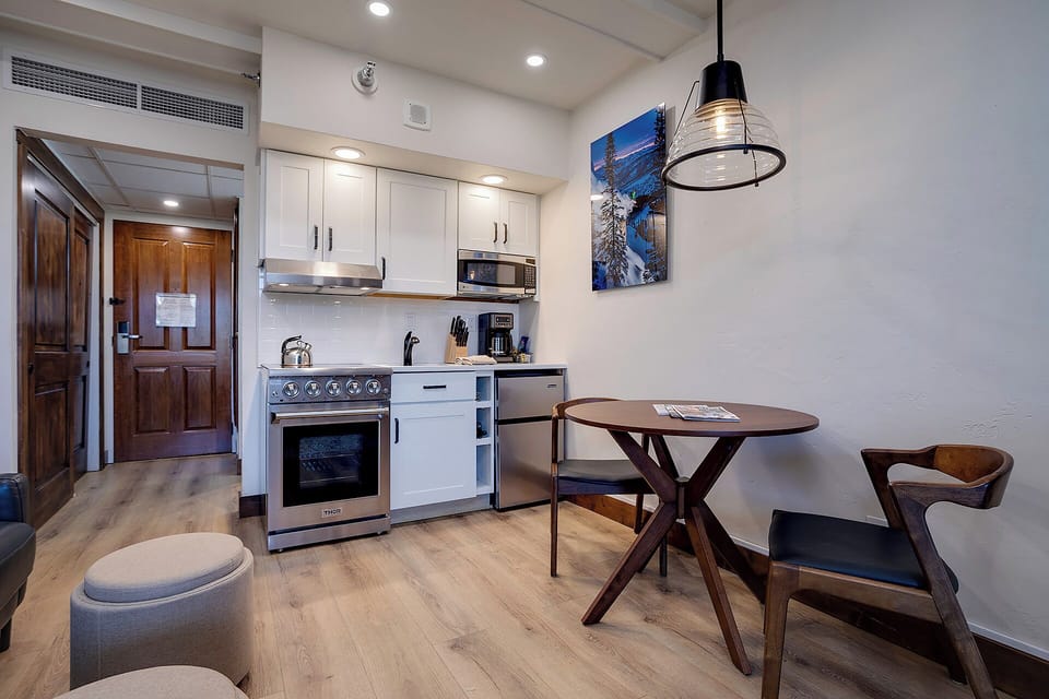 Your stylish open-concept suite features a fully equipped kitchen with stainless appliances, cozy dining nook, and modern air-conditioned comfort for relaxing mountain getaways.