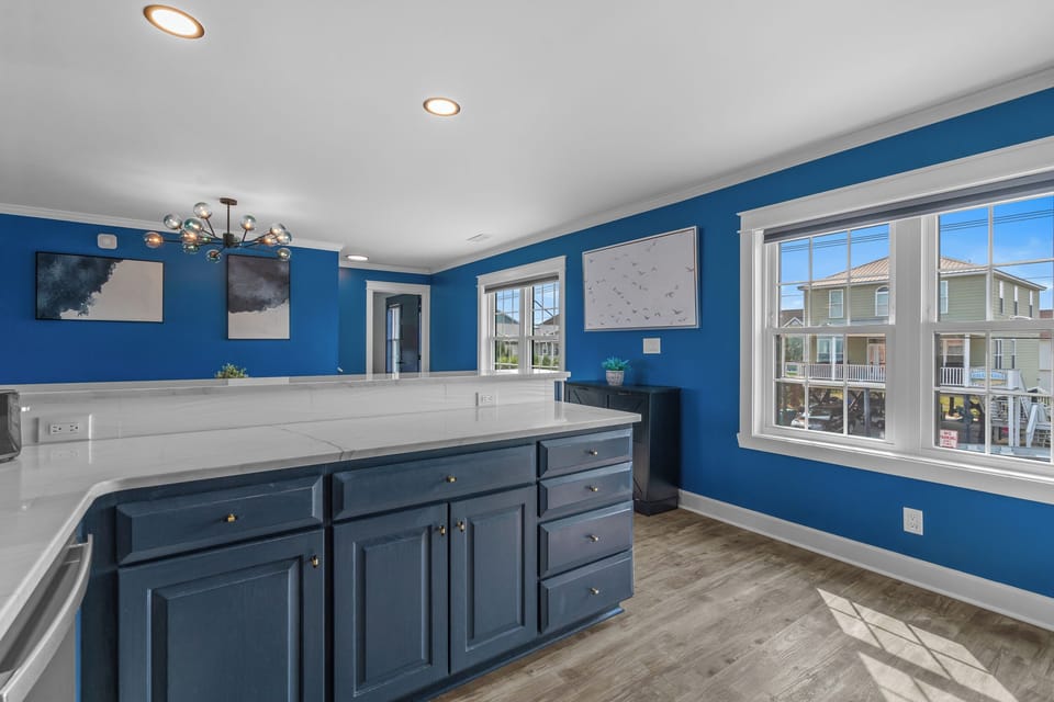 Enjoy morning light and bold coastal color from the kitchen. With polished counters, navy cabinetry, and a wide open layout, this space makes meal prep feel effortless.