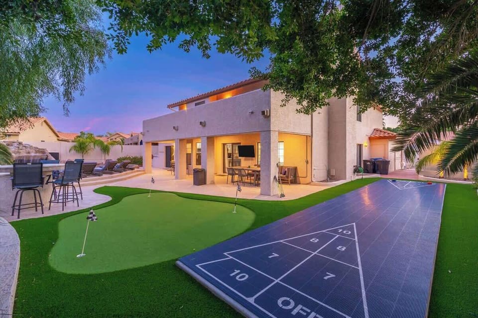 This property features a spacious backyard with a miniature putting green, shuffleboard court, and covered patio area—offering resort-style amenities in a tranquil neighborhood setting.