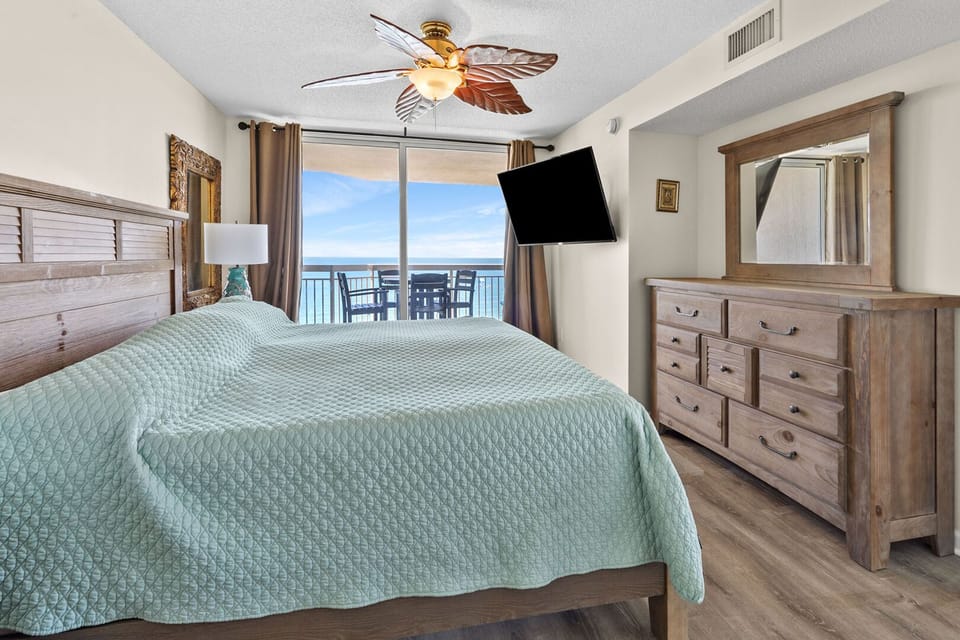Bedroom with sliding doors to the ocean-view balcony at Crescent Shores PH 1812, a 4-bedroom condo rental