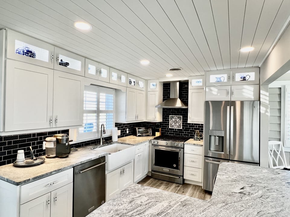 The gourmet kitchen features a gas propane KitchenAid stove, drawer microwave