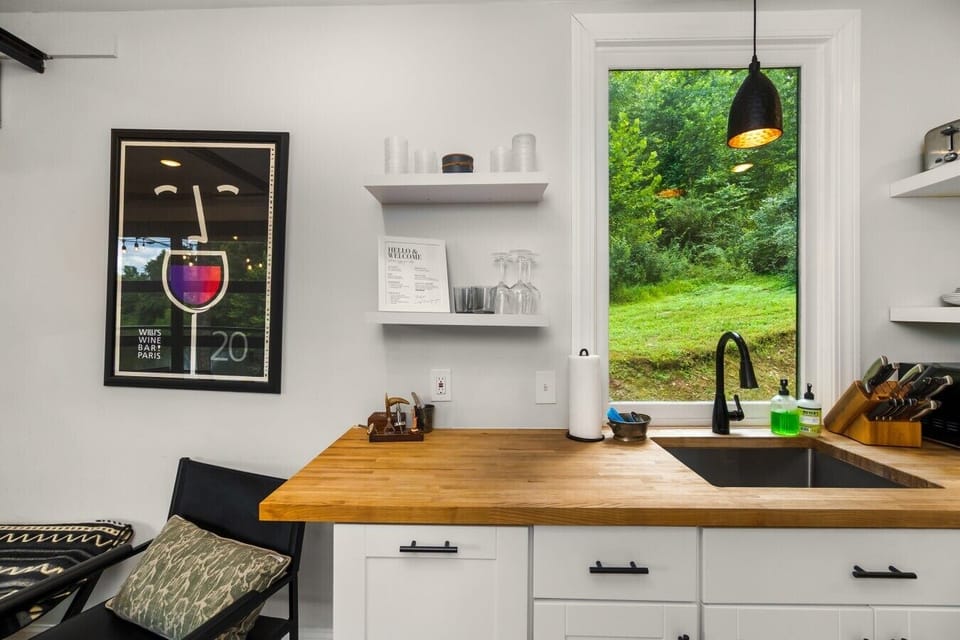 Enjoy peaceful wooded views while cooking or sharing a meal in this thoughtfully designed kitchen and dining space.