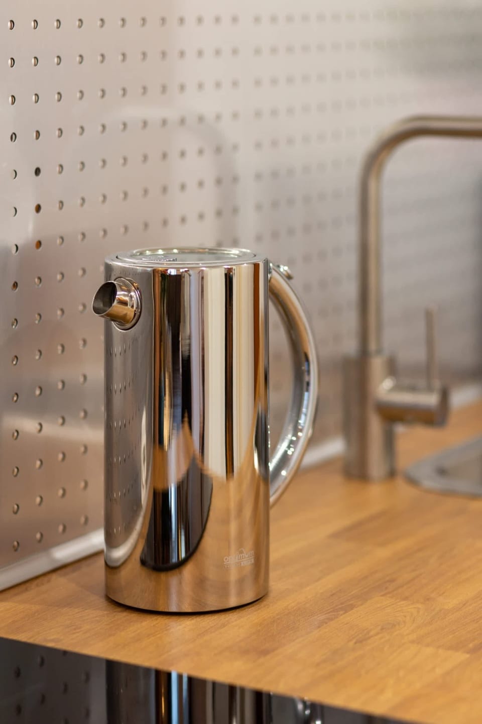A polished steel kettle on the kitchen countertop, complementing the sleek and practical design.
