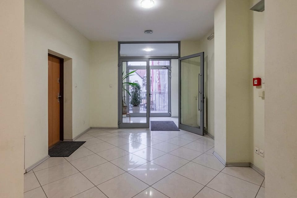 The apartment building's hallway with tiled flooring and simple decor, creating a welcoming entrance for residents and guests.