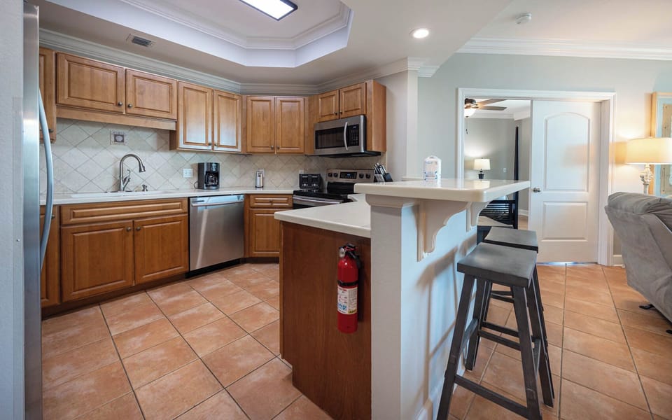 Prepare meals in this kitchen with elegant cabinetry, stainless appliances, and spacious countertops