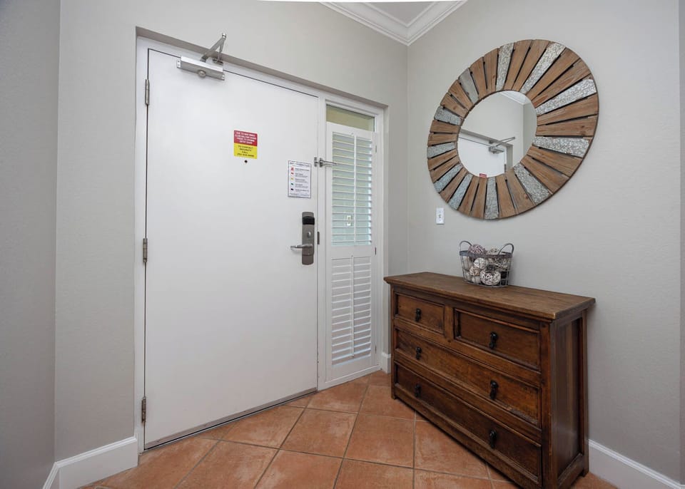 Step into a welcoming entryway highlighted by natural light and charming decor, setting the tone for your stay