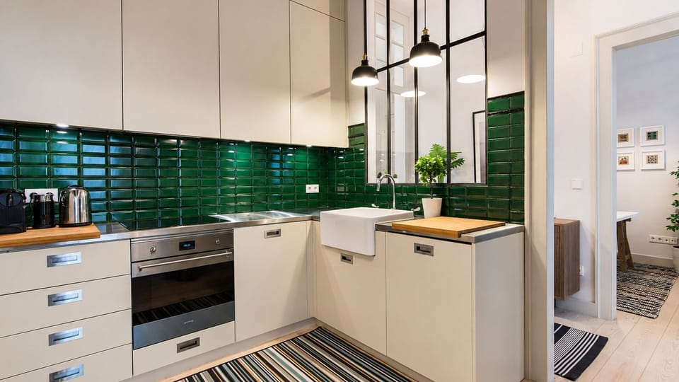 Unleash your inner chef in this stylish, fully equipped kitchen, featuring sleek green subway tiles and modern appliances that make cooking a pleasure. The smart design, including a spacious farmhouse sink and ample counter space, ensures every culinary n
