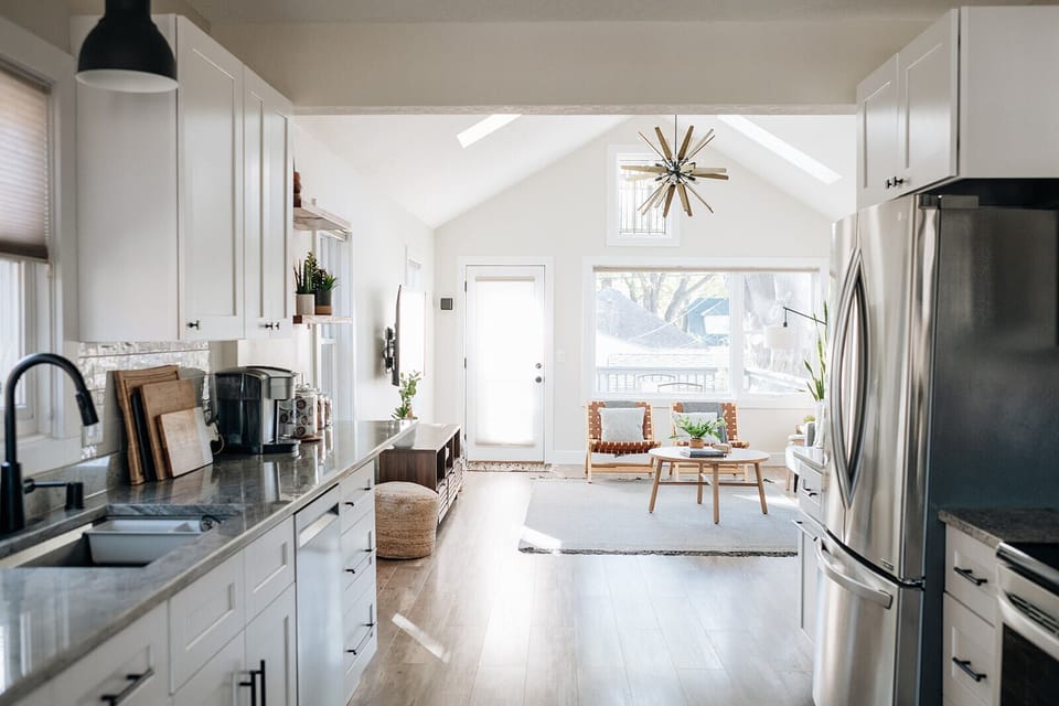 Open concept with deck off main level with gas grille and furniture