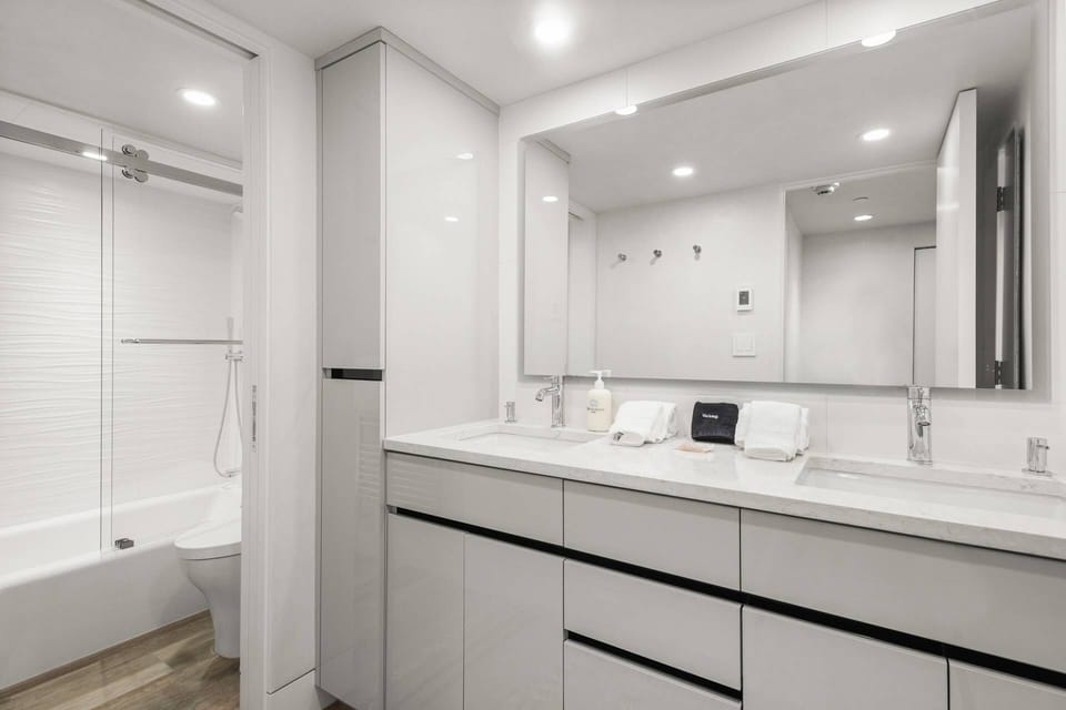 The bathroom offers a heated towel bar, Toto Washlet toilet, and lighted mirrors, creating a spa-like ambiance.