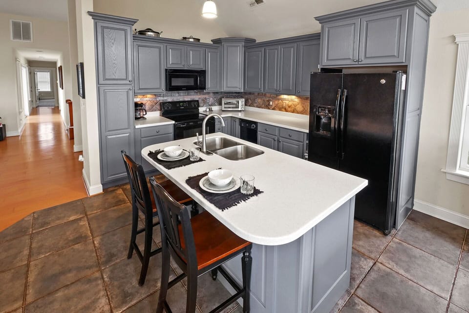 The kitchen island includes a bar with additional seating for 2 people.