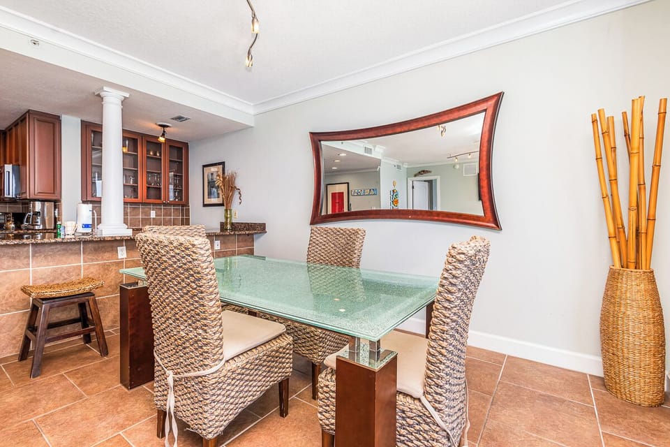 Gather around this inviting dining space where your group can share meals and stories. Textured woven chairs, a sleek glass table, and tropical bamboo accents create a relaxed yet stylish atmosphere.