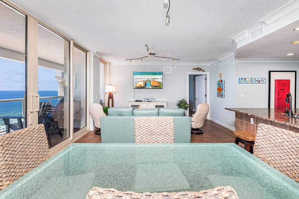 Bright coastal living space with turquoise accents and beachside decor opens to your private oceanfront balcony. Relax in comfort while soaking in endless water views through floor-to-ceiling glass doors.