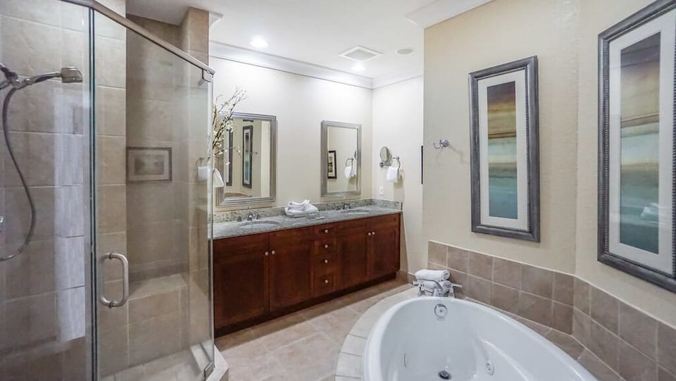 Soak away your cares in your spa-inspired bathroom, with a deep soaking tub, elegant walk-in shower, and double vanity wrapped in warm wood and polished stone.