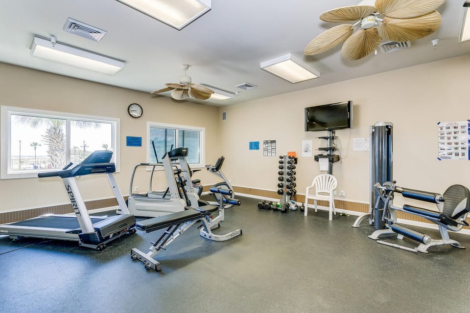 Stay active in your bright fitness center with cardio machines and free weights. Large windows let in natural light while you work out, and tropical palm trees frame the views outside.