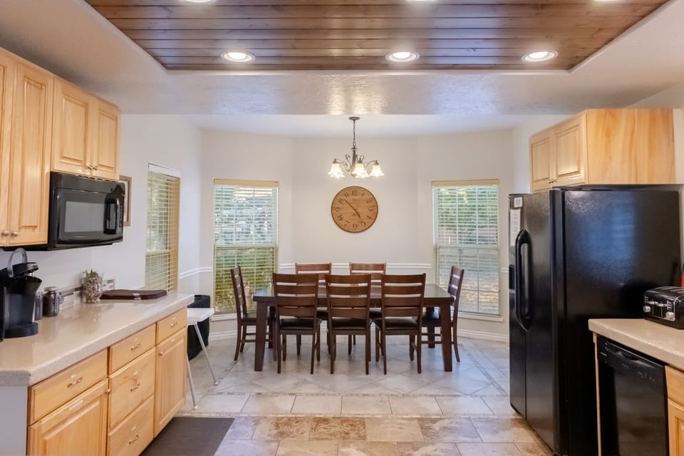 Dining area off of kitchen with table and 8 seats.