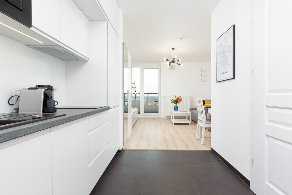 A functional galley kitchen with a bright, minimalist design and modern fixtures.
