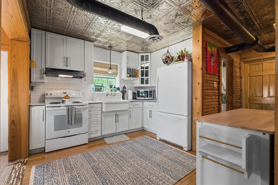 Kitchen leads to the second bath, staircase with loft room, and primary ensuite bedroom