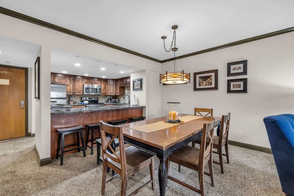 Gather for meals at the centrally located dining table, conveniently situated next to the kitchen bar offering additional seating.