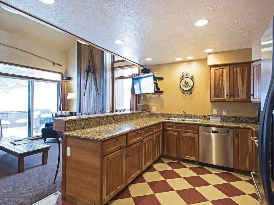 The kitchen features stainless steel appliances, an eat-in bar with seating for four, a flat-screen TV connecting the space to the living area and an open layout that helps you stay connected to the fun.