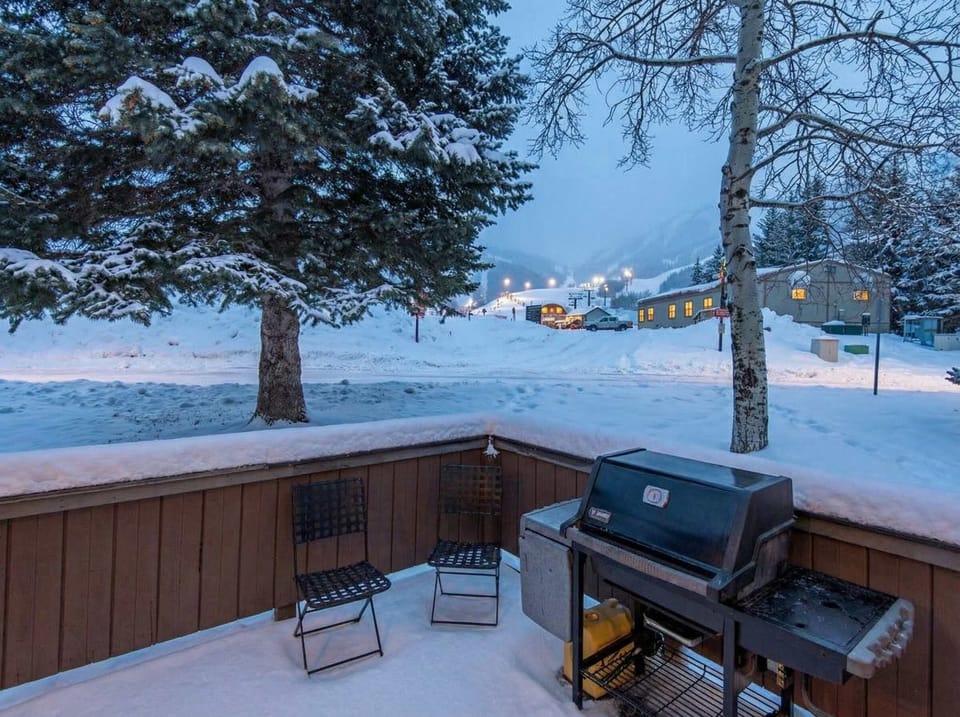 A lovely patio space with views of Park City Mountain Resort features a BBQ grill and outdoor dining area that seats four.