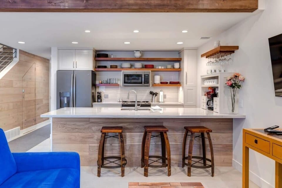Fully-equipped kitchen with high-quality stainless steel appliances, plenty of countertop space, and breakfast bar seating