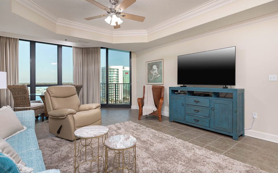 Relax in the inviting living area featuring a plush recliner, sofa with queen sleeper, stylish decor, and a large TV