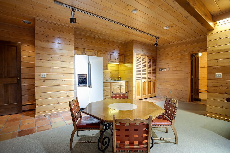 Gather around your rustic dining table in this warm log cabin retreat, where exposed beams and wood create cozy mountain vibes.