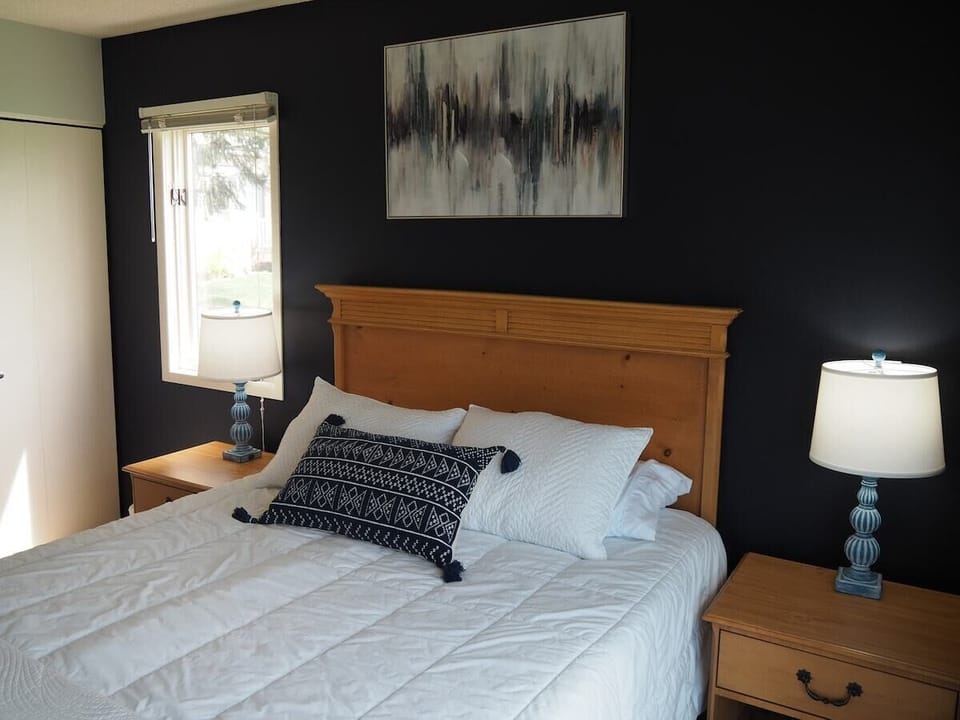 GUEST BEDROOM:  Features a queen-size bed, private entrance from the deck, nightstands with lamps, a dresser, closet, chair, and its own television.