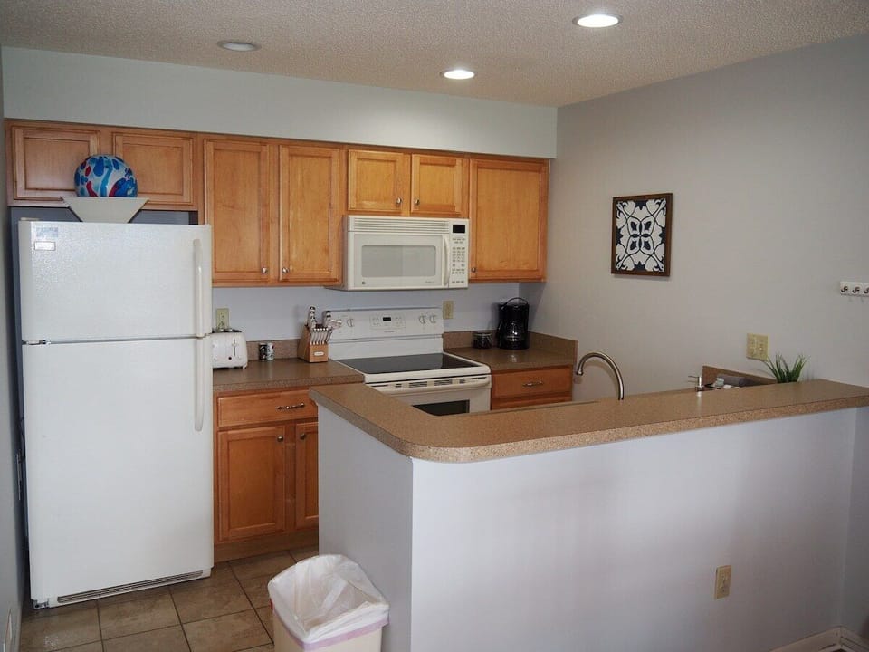 KITCHEN:  The condo has a convenient and efficient full kitchen with all appliances including a dishwasher.  A good collection of cooking and dining utensils is also included with the rental.