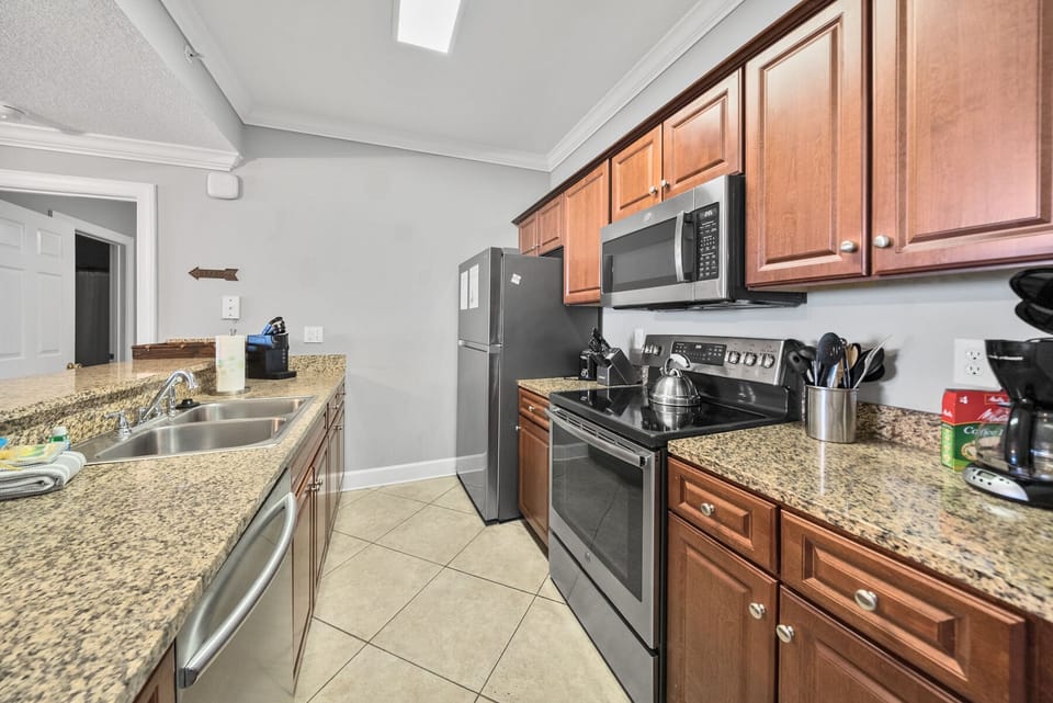 Your fully equipped kitchen features granite countertops, stainless steel appliances, and warm wood cabinetry—perfect for preparing meals together.