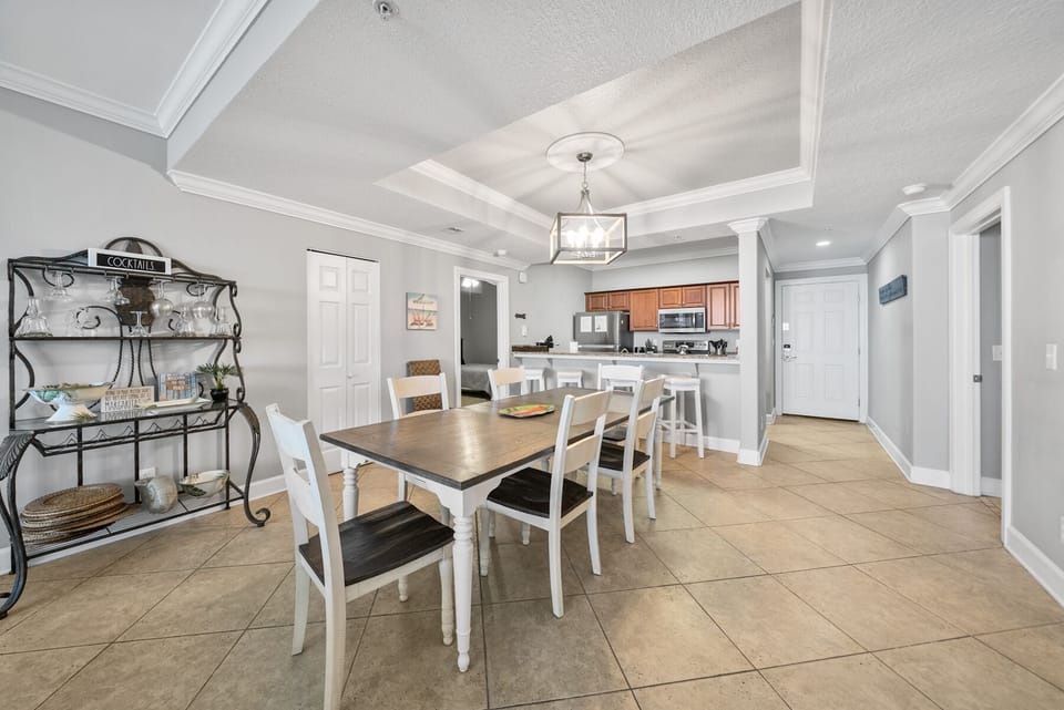 Your open dining space flows seamlessly into the kitchen, with elegant coffered ceilings and warm tile floors creating the perfect gathering spot.
