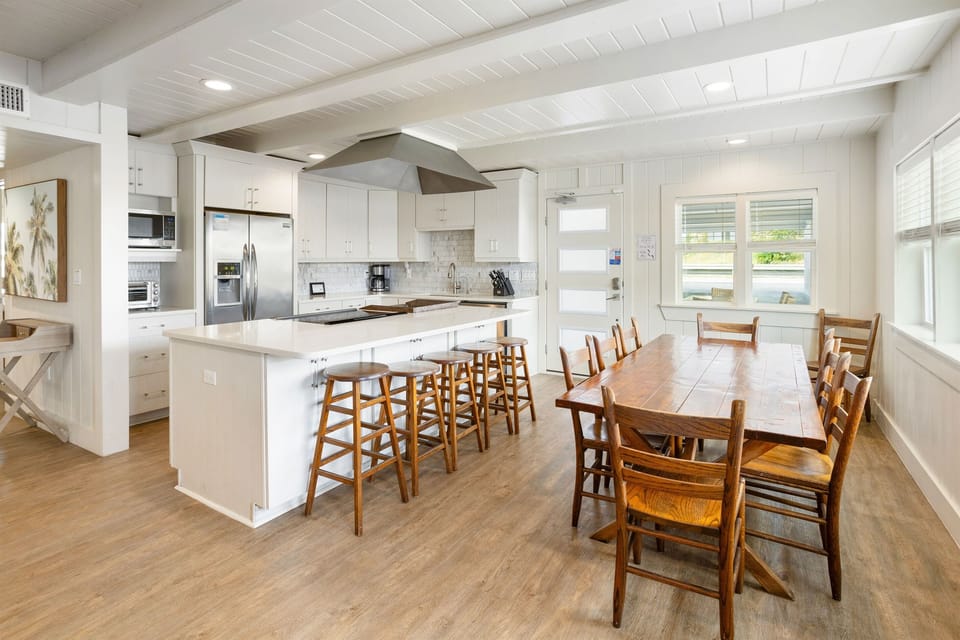 Your spacious kitchen flows seamlessly into the dining area, perfect for cooking family meals and gathering around the warm wood table.