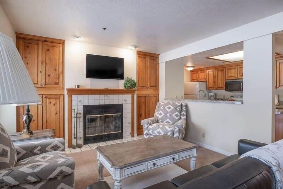 Cozy up with your loved ones in the living room with a comfortable sofa and armchair seating, an indoor wood fireplace, and a flat-screen TV