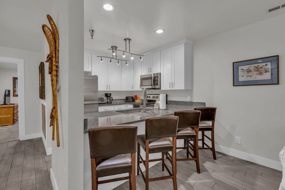Kitchen: Stainless steel appliances, drip coffee maker, cooking utensils, tableware, bar seating for 4