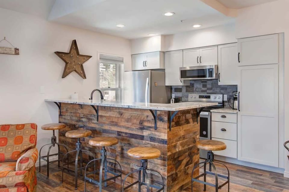 The striking wood detail adds an unique, rustic touch to the eat-in bar/island that bridges the kitchen and living areas with seating for five.