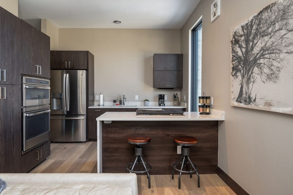 Kitchen is fully stocked, has a peninsula with stools, and stainless appliances