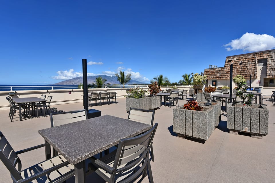 Rooftop outdoor dining with table, chairs, BBQs, and kitchenette.