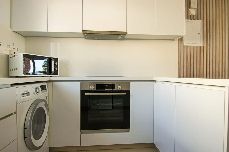 Deluxe Apartment | Private kitchen | Fridge, electric kettle, highchair, dining tables