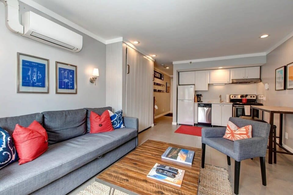 Another view from the gorgeous living area highlights the efficient layout and bright decor of this fabulous studio space. A queen-size murphy bed tucks away during the day and opens up the kitchen and dining areas.