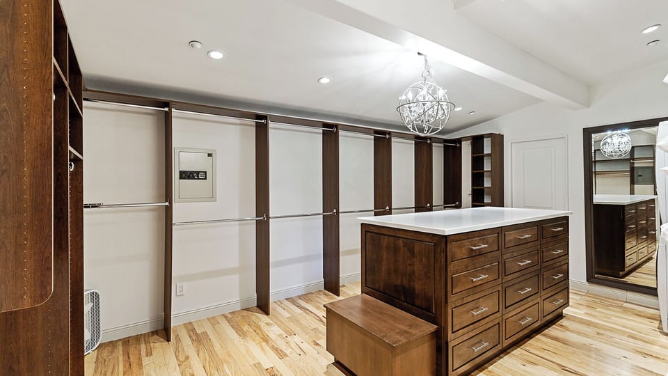 Primary Walk-in closet with built-in shelving and boutique-inspired lighting.